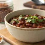 A bowl of freshly made chili with dry beans, garnished with cilantro.