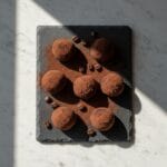 Delicious cocoa dusted chocolate truffles on a slate platter.