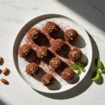 Dark chocolate almond truffles on a white platter