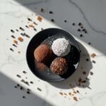 Delicious date cacao truffles on a marble table.