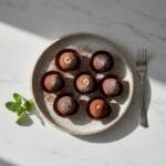 Delicious homemade chocolate truffles on a white marble table.