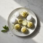 Delicious white chocolate pistachio truffles on white marble.