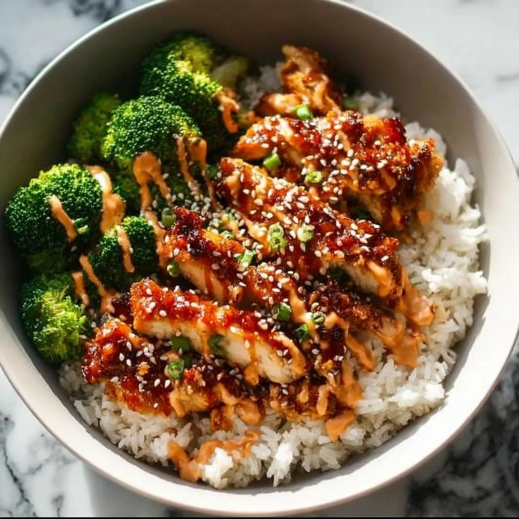Delicious sticky chicken rice bowls garnished with herbs and vegetables