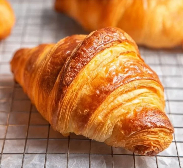 Freshly baked homemade croissants on a rustic wooden table